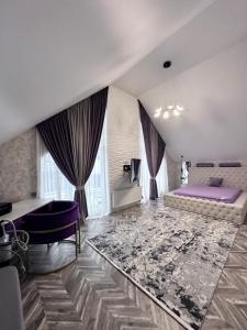 a large living room with a purple couch and a bed at Новий будинок для Вашого чудового відпочинку поряд Київ in Kyiv