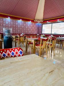 a restaurant with tables and chairs in a room at Rum Elegant luxury camp in Wadi Rum