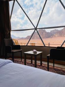 ワディ・ラムにあるRum Elegant luxury campのベッド付きの客室で、砂漠の景色を望めます。