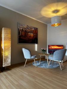 sala de estar con 2 sillas y mesa en Moderne Wohnung, zentral gelegen en Bielefeld