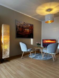 un salon avec deux chaises et une table dans l'établissement Moderne und gemütliche Wohnung, zentral gelegen, à Bielefeld