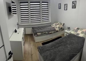 um pequeno quarto com 2 camas e uma janela em Apartament ,,Eden” em Zator