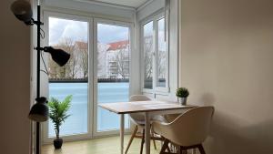 mesa y sillas en una habitación con ventana grande en Moderne Wohnung, zentral gelegen en Bielefeld