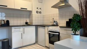 una cocina con electrodomésticos blancos y una maceta en Moderne Wohnung, zentral gelegen en Bielefeld
