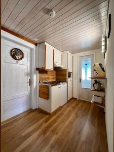 a kitchen with white cabinets and a wooden floor at Chalet Maria Interlaken in Interlaken
