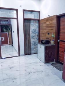a bathroom with a sink in a room with a door at Kishore villa fully furnished house in Jaipur