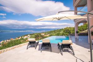 a villa with a swimming pool and an umbrella at Apartment with a private pool, enchanting view, beach - by Traveler tourist agency ID 2122 in Vrbnik