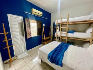 1 dormitorio con 2 literas y pared azul en Mini Hostel en Tutóia