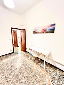 a room with a white desk and a painting on the wall at A due passi da Brignole in Genoa