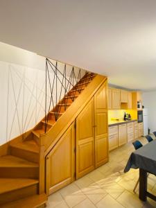 una cocina con armarios de madera y una escalera en La maison Girafe en Faverolles