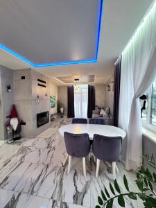 a living room with a marble floor and a table and chairs at Новий будинок для Вашого чудового відпочинку поряд Київ in Kyiv