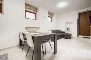 a dining room with a table and chairs and a couch at C-Apartment Lake Garda in Salò