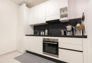 a kitchen with white cabinets and a stove at C-Apartment Lake Garda in Salò