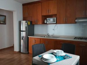 a kitchen with a table with chairs and a refrigerator at Confortable Apartmento in Guanajuato