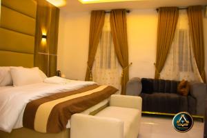 a hotel room with a bed and a couch at TRILLIONS HOTEL AND APARTMENT in Benin City