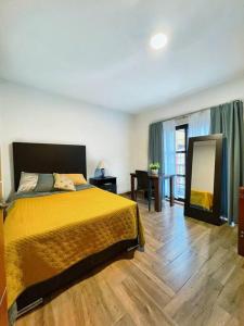 1 dormitorio con cama, mesa y espejo en Confortable Apartmento, en Guanajuato