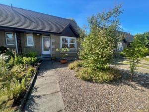 a house with a gravel yard in front of it at Peaceful Getaway In Peebles in Peebles