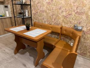 drewniana ławka z drewnianym stołem i biurkiem w obiekcie Sofija apartamenti w mieście Dyneburg