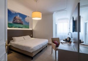 una camera con letto e scrivania con computer di Hotel Delle Palme a Lecce