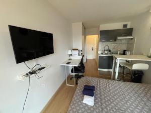 a living room with a bed and a flat screen tv at Exclusive Private Apartment by Warilco - Pleyel 25 m2 - À 1 minute de la station métro Carrefour Pleyel in Saint-Denis