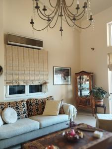 uma sala de estar com um sofá e duas janelas em Villa Myrto em Kyparissia