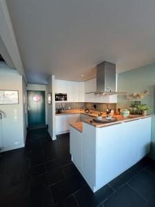 cocina con armarios blancos y encimera en Charming waterfront cabin in Ballstad, Lofoten en Ballstad
