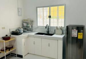 a kitchen with a sink and a refrigerator at Camella Mabini Cabanatuan in Cabanatuan