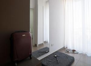 una stanza con specchio e valigia sul pavimento di Hotel Delle Palme a Lecce