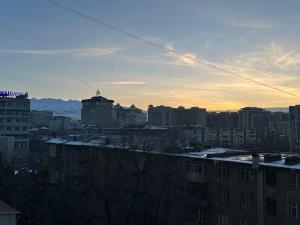 a view of a city at sunset with buildings at 1-room apart. 21 on Usenbaeva 52 near Eurasia shopping center in Bishkek