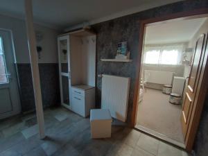 a room with a kitchen with a refrigerator and a mirror at Ferienwohnung Ankerplatz Züssow in Züssow +3 photos