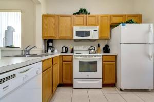 a kitchen with white appliances and wooden cabinets at Villas at Regal Palms-4 Bedroom3.5 bath Townhouse in Davenport