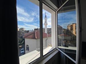 een raam met uitzicht op de skyline van de stad bij Tirana Elegant Apartment in Tirana