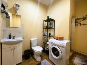 een badkamer met een toilet en een wasmachine bij Sofija apartamenti in Daugavpils