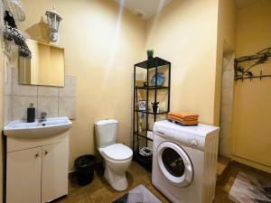 a bathroom with a toilet and a washing machine at Sofija apartamenti in Daugavpils