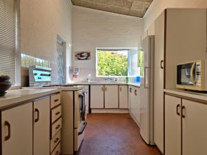 une grande cuisine avec des placards blancs et une fenêtre dans l'établissement 75 Protea Drive, sleeps 6/8 guests., au Cap
