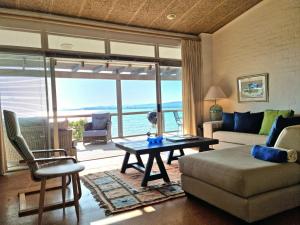 una sala de estar con un sofá y una mesa en '75 Protea' 4 Bedroom Holiday Home for 8 with Private Pool and Ocean Views, en Ciudad del Cabo
