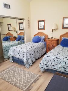 1 dormitorio con 2 camas y espejo en Island Life, en St. Augustine Beach