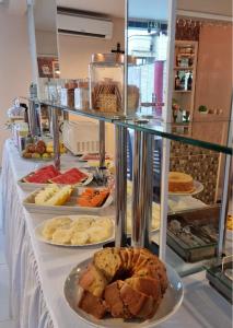a buffet line with different types of bread and pastries at MONTERREY HOTEL in Santa Inês
