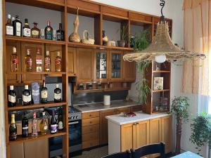 uma cozinha com armários de madeira com garrafas de álcool em Kobran em Kuršumlija