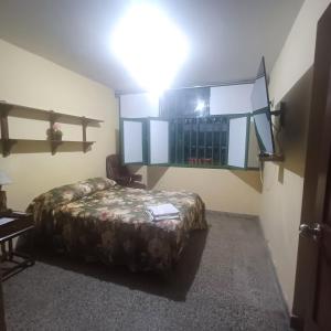 Habitación con cama y techo con luz. en Julia house en Huanchaco