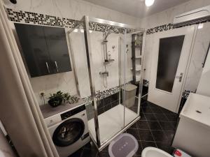 a bathroom with a shower and a washing machine at Apartma CIK in Bovec