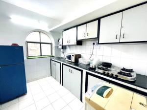 a kitchen with white cabinets and a blue refrigerator at Luxurious 1BHK with a Pool AniRah Homes in Colva in Colva