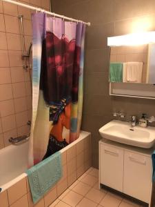 a bathroom with a shower curtain with a picture of a woman at Vue sur lac et proche du centre in Montreux
