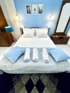 1 cama grande con sábanas blancas y almohadas azules en Luxurious 1BHK with a Pool AniRah Homes in Colva, en Colva