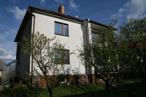 a white house with trees in front of it at Ubytování v Proseči in Proseč