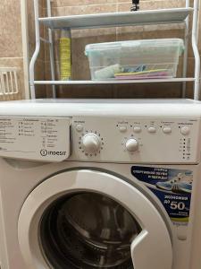 a white washing machine with a shelf on top of it at 1-room apart. 21 on Usenbaeva 52 near Eurasia shopping center in Bishkek