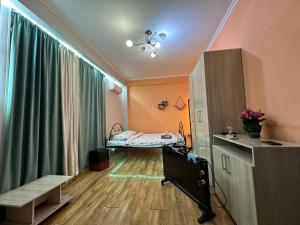 Habitación hospitalaria con cama y cortina verde en 1-room apart. 21 on Usenbaeva 52 near Eurasia shopping center, en Bishkek