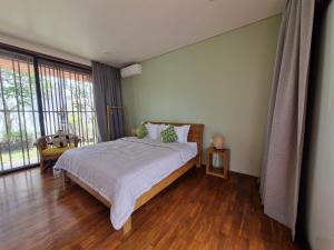 1 dormitorio con cama y ventana grande en Villa Capella, en Canggu