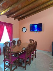 mesa de comedor con sillas y reloj en la pared en Cabañas Maciel en San Rafael