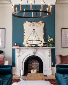 a living room with a fireplace and a chandelier at The August House in Windsor